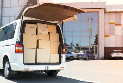 A white delivery service car with boxes inside