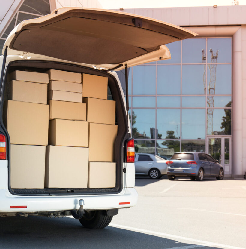 A white delivery service car with boxes inside